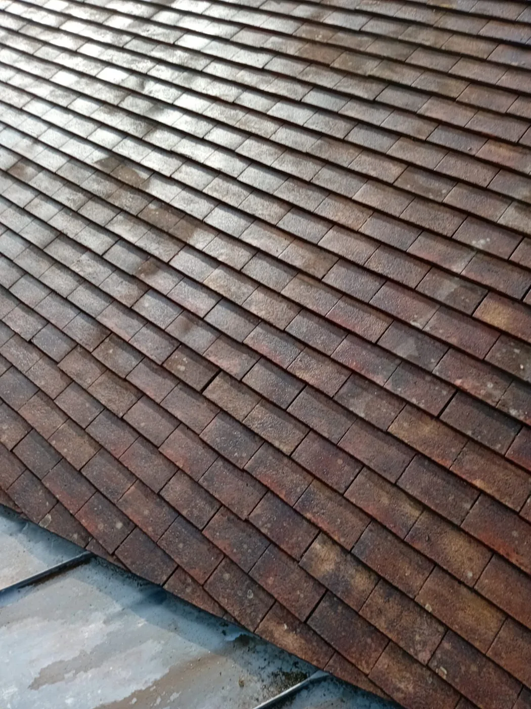 Détail d'une couverture en tuiles plates patinées